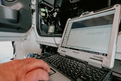 technician using a laptop on a semi repair