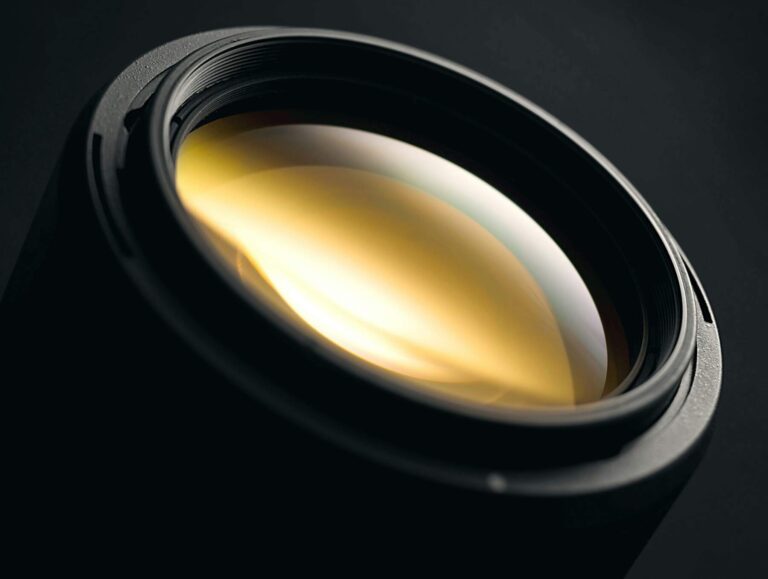 a close up of a camera lens with a yellow reflection